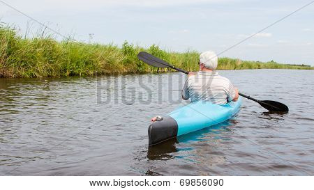 Man Paddling In A Blue Kayak