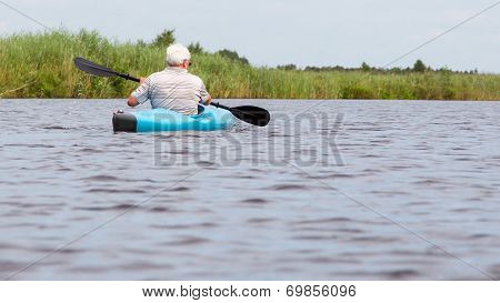 Man Paddling In A Blue Kayak