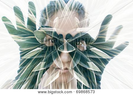 Multiple exposure portrait of attractive woman in black gloves forming glasses combined with photograph of cactus