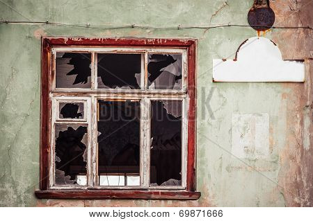 Smashed Glass Window With Old Wooden Frame On Grunge Wall Damaged House