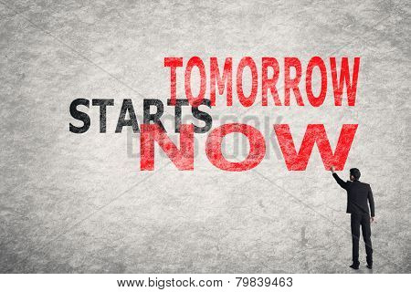 Asian businessman write text on wall, Tomorrow Starts Now