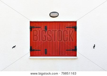 Old fashioned red wooden window shutters closed