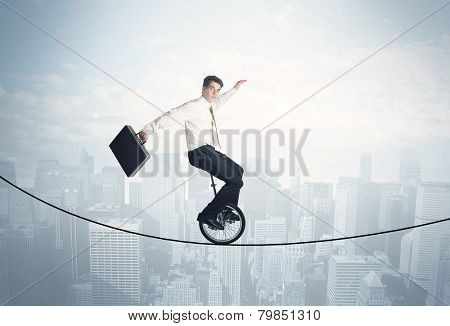 Brave guy riding a monocycle on a rope above cityscape concept