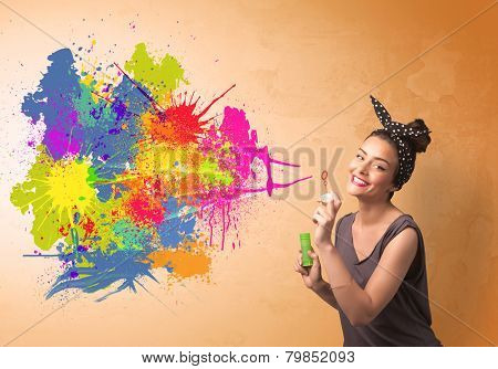 Cute girl blowing bubble spalsh graffiti into wall