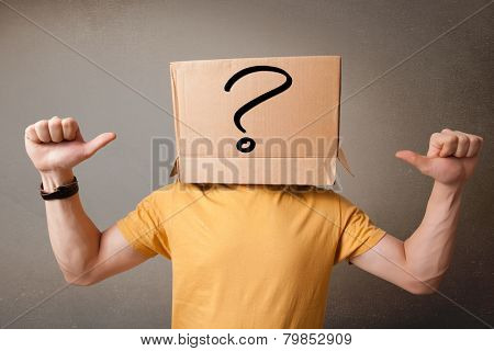 Young man standing and gesturing with a cardboard box on his head with question mark
