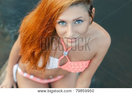 Sexy Girl With Red Hair In A Bikini On The Beach. Looking Up