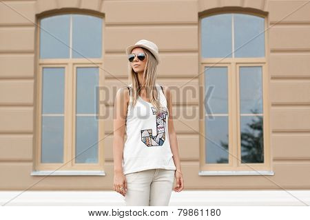 Girl In Sunglasses And Hat Standing Near The House