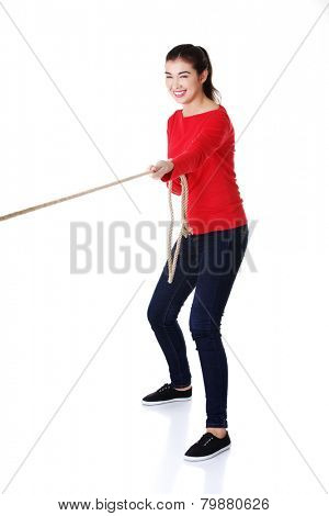 Full length strong woman puling rope.