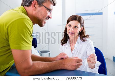 Doctors nurse with telephone in front desk making appointment with patient
