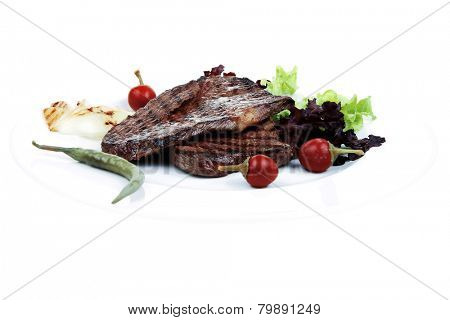 meat food : two grilled steak with chili and red peppers , green lettuce salad , on dish isolated over white background