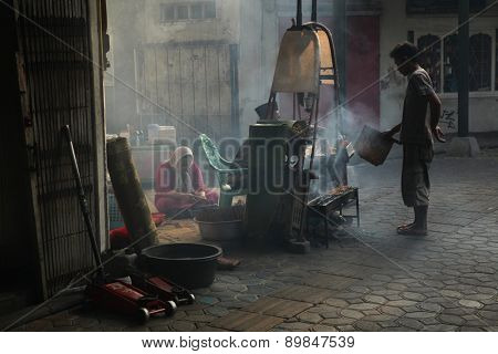 SURAKARTA, INDONESIA - AUGUST 17, 2011: Vendors prepare and sell street food in Surakarta, Central Java, Indonesia. 