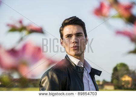 Good looking male model at couuntryside, among flowers