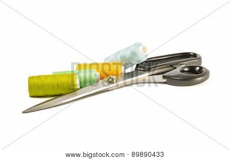 Colored threads with scissors on a white background