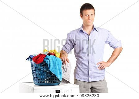 Guy standing by a washing machine with a laundry basket on it isolated on white background