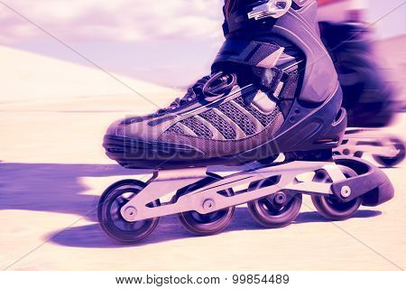 closeup of the feet of a young man roller skating with inline skates, with a filter effect