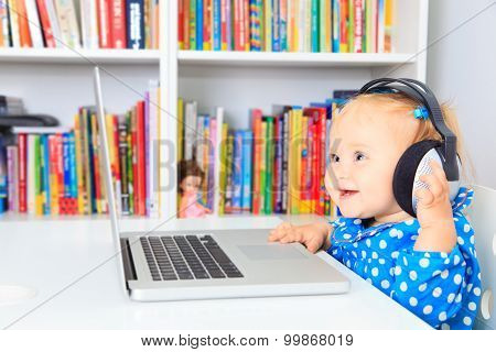 little girl with headphones and laptop