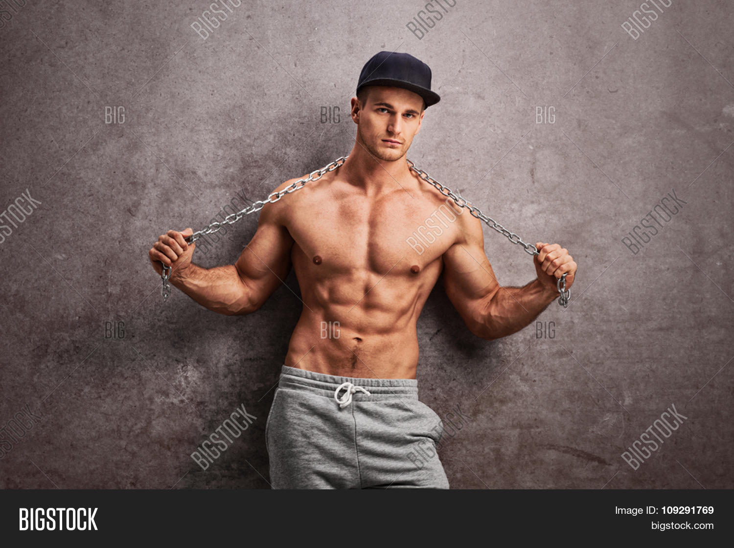 цепочка зажатая в кулаке. парень в цепях. рука держит цепь. парень раб. человек в цепях.