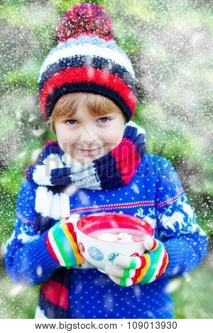 Little kid boy holding big cup with chocolate drink in winter