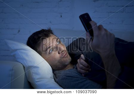 Man In Bed Couch At Home Late At Night Using Mobile Phone In Low Light Watching Online Porn