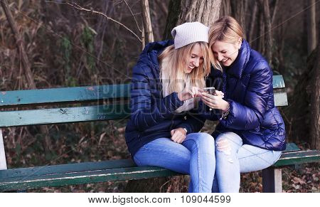 Young woman sitting on bench with her best friend