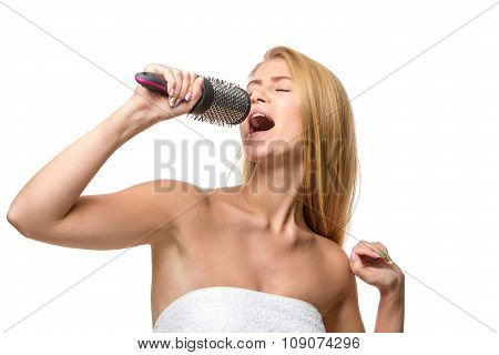 Happy pretty woman in towel singing using comb having fun