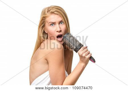 Surprised pretty woman in towel singing using comb having fun