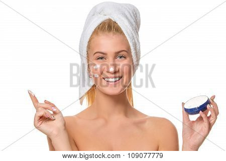 Beautiful laughing young woman with facial cream on her nose