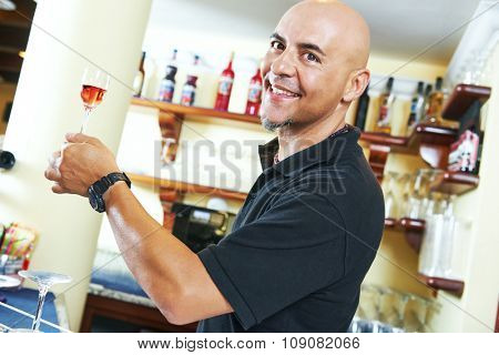 Portrait of sommelier holding a little wine glass with aperitive alcohol drink 