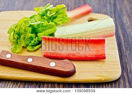 Rhubarb With Knife And Leaf On Board