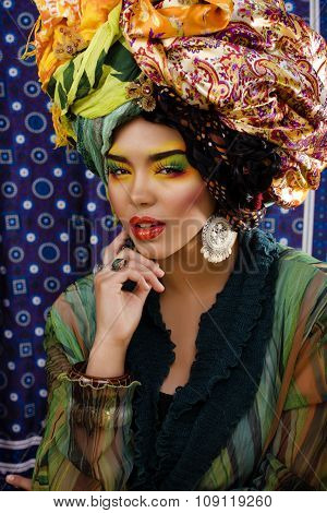 beauty bright woman with creative make up, many shawls on head like cubian woman, ethno look