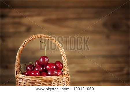 Ripe Sweet Cherries in  Basket closeup on Rustic Wooden background