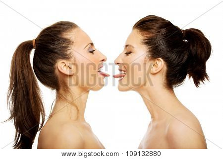 Two attractive women with make up showing their tongs.