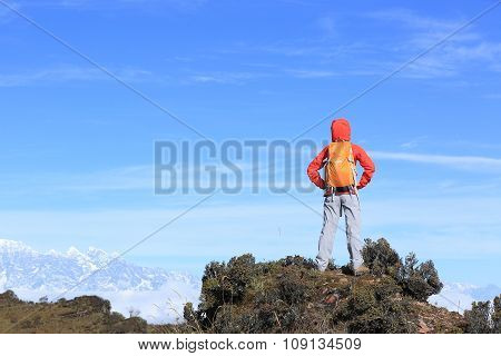 young woman hiker hiking on mountain peak