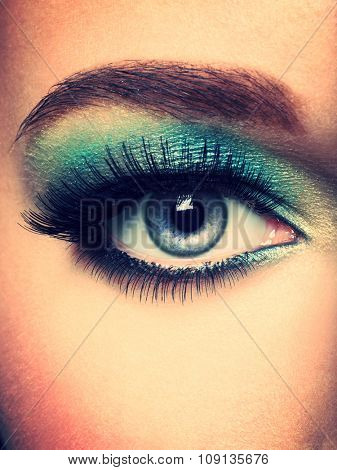 Woman's eye with green eye make-up. Long eyelashes