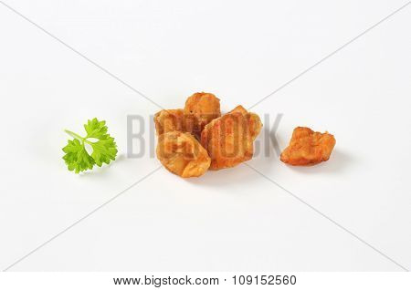 handful of pork greaves on white background