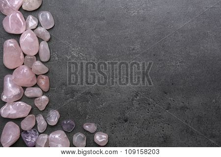 Frame of pink quartz on grey background, copy space