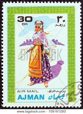 AJMAN EMIRATE - CIRCA 1968: Stamp shows a woman in traditional costume
