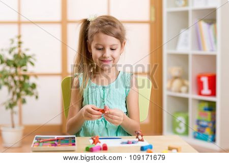 Kid playing modeling plasticine or molding clay