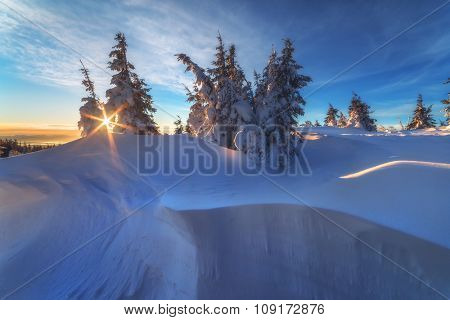 Fantastic orange evening landscape glowing by sunlight. Dramatic wintry scene with snowy trees. Kukul ridge, Carpathians, Ukraine, Europe. Merry Christmas!
