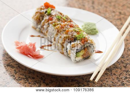 Fancy Philadelphia sushi roll topped with roe sushi sauce and chopped scallions