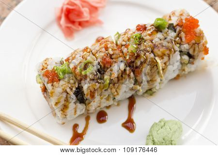 Fancy Philadelphia sushi roll topped with roe sushi sauce and chopped scallions