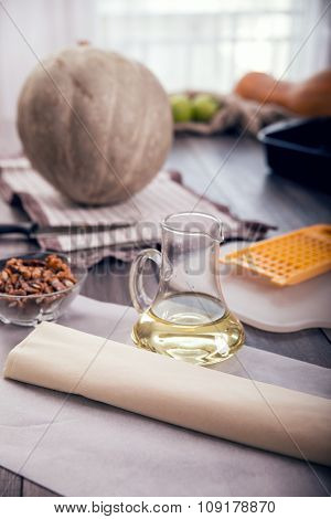 Preparing pie with pumpkins on wooden table, selective focus