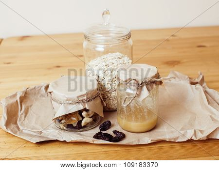 real comfort wooden kitchen with breakfast ingredients close up in glass, honey, oatmeal, milk, mues