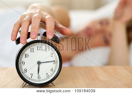 Stretching Hand Of Sleepy Young Woman Trying Kill Alarm Clock