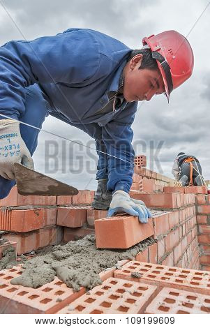 Bricklayer works on 15th floor of building