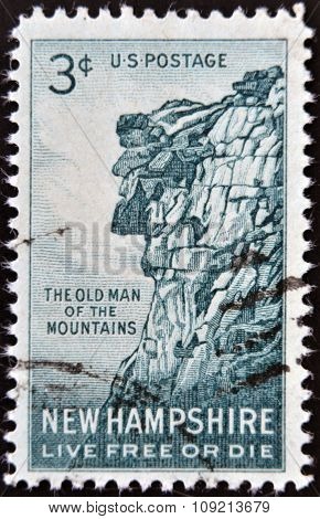 A stamp printed in USA shows Old man of the mountains New Hampshire Live Free or Die circa 1955