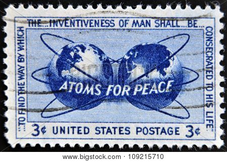 a stamp printed in USA shows Atomic Energy Encircling the Hemispheres Atoms for Peace Policy