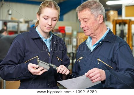 Apprentice Engineer Measuring Component With Micrometer
