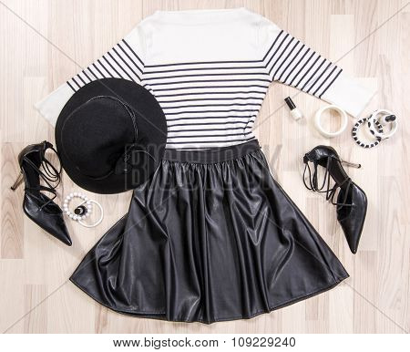 Striped Blouse And Leather Skirt With Accessories Arranged On The Floor.