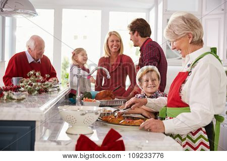 Extended Family Group Preparing Christmas Meal In Kitchen